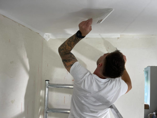 Photo d'illustration de l'article "Les avantages de faire appel à un peintre professionnel". Sur la photo se trouve un peintre de PrestigeColor en train de préparer un plafond avant de le peindre.